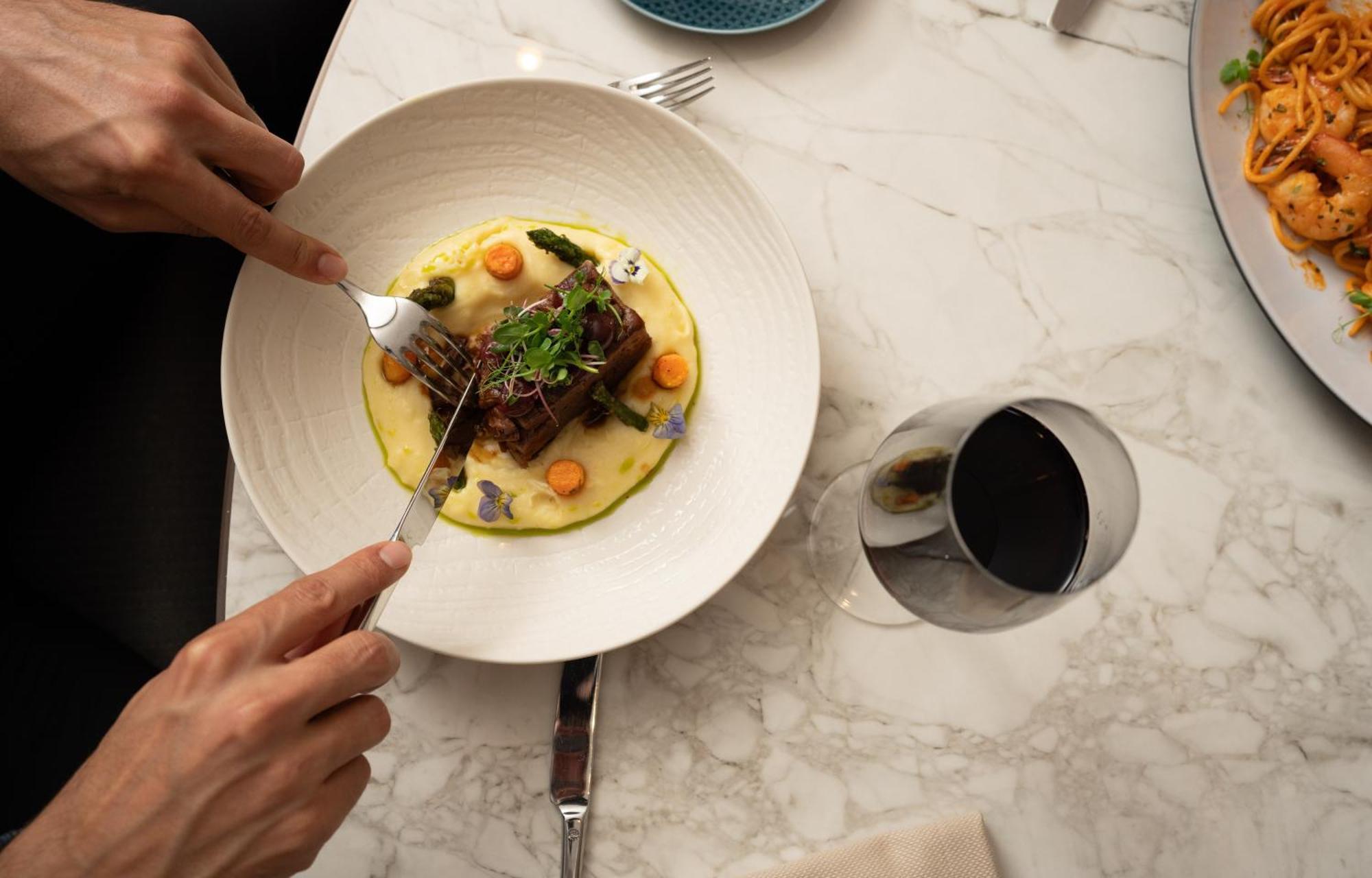 Address Istanbul Hotel Exterior photo A person using a fork to cut into a meal